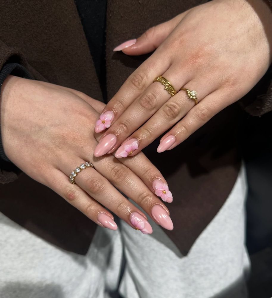Nude nagels met roze bloemen en ringen