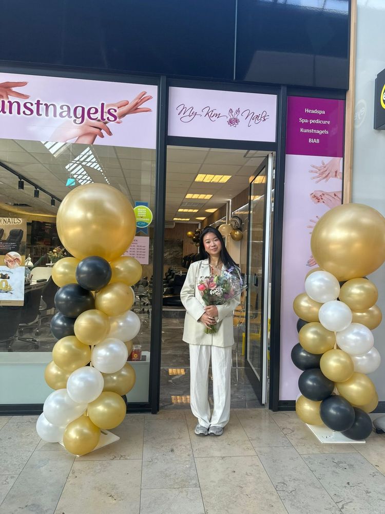 De eigenaar van My Kim Nails bij de ingang van haar salon op de openingsdag